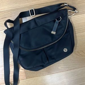 Lululemon festival bag in black with gold hardware.